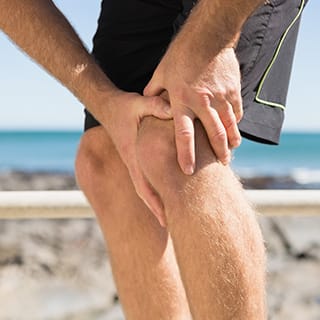 運動中に膝の痛みを感じる男性のイメージ